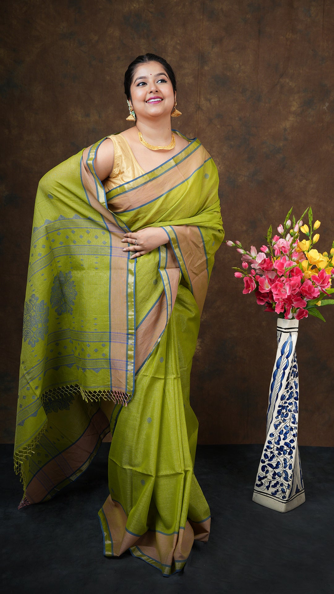 Bright green tissue saree with golden zari work, beige and blue border, and blue butis/pallu. Includes 0.8m running blouse. 5.5 meter tangail weave