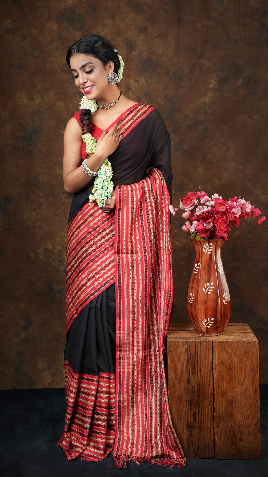A black and red tangail saree - A soft cotton tangail saree in black with broad red-beige border and matching pallu. This vibrant Tangail saree, Jaquard weave, soft cotton saree is perfect for festive moments.
