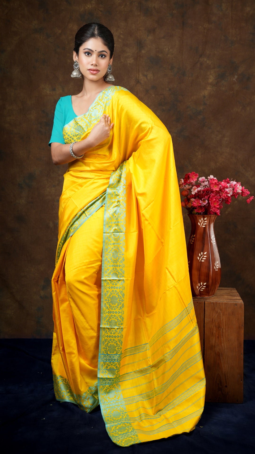 A yellow silk tangail saree - A yellow tangail silk saree with firozi border and striped pallu. This bright Tangail saree, silk saree is a beautiful pick for ethnic elegance.