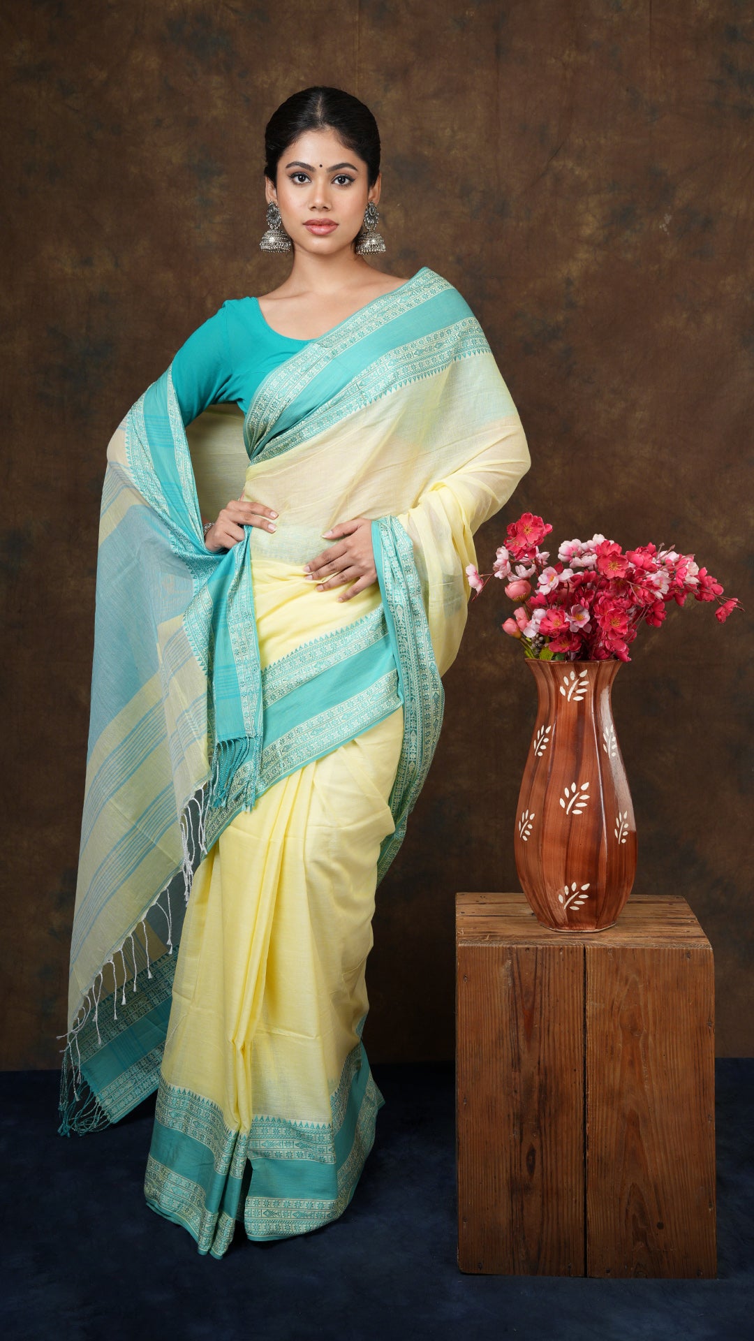 A lemon yellow tangail saree - A soft cotton tangail saree in lemon yellow with sea green borders. This subtle Tangail saree is perfect for everyday ethnic fashion.