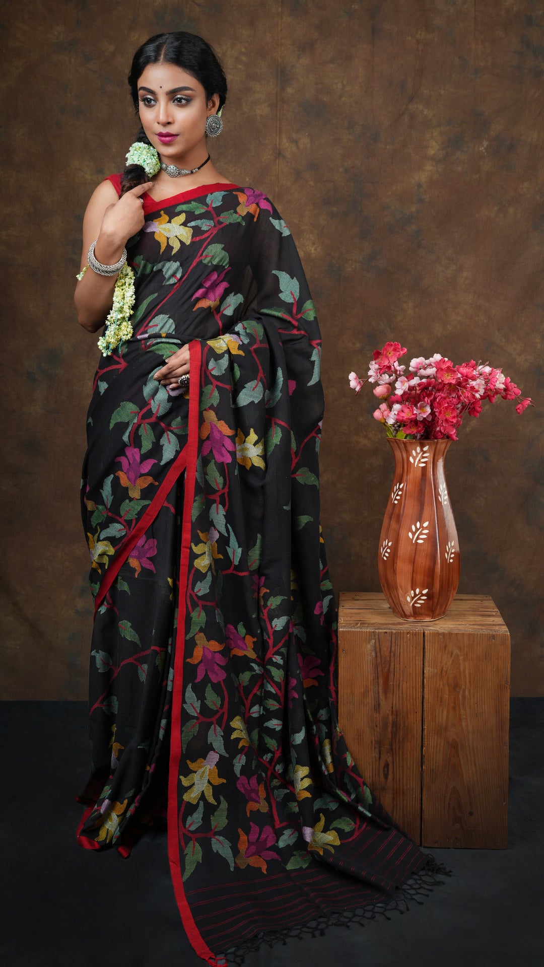  A black multicolor dhakai saree - A black soft cotton dhakai saree with all-over floral motifs in multicolour. This graceful Dhakai saree is ideal for grand traditional occasions