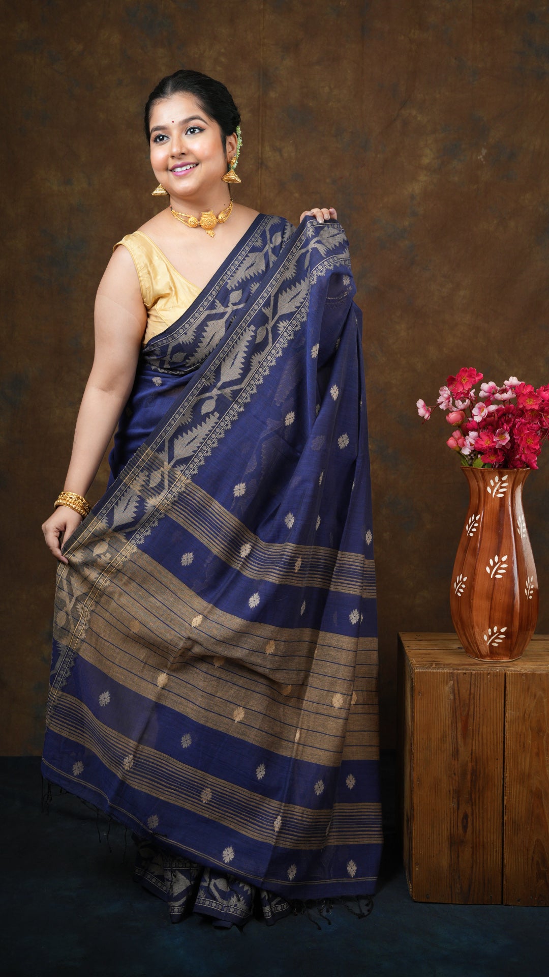 A blue dhakai saree - A soft cotton blue dhakai saree with beige butis, pallu and border. This elegant Dhakai saree is ideal for graceful cultural dressing.