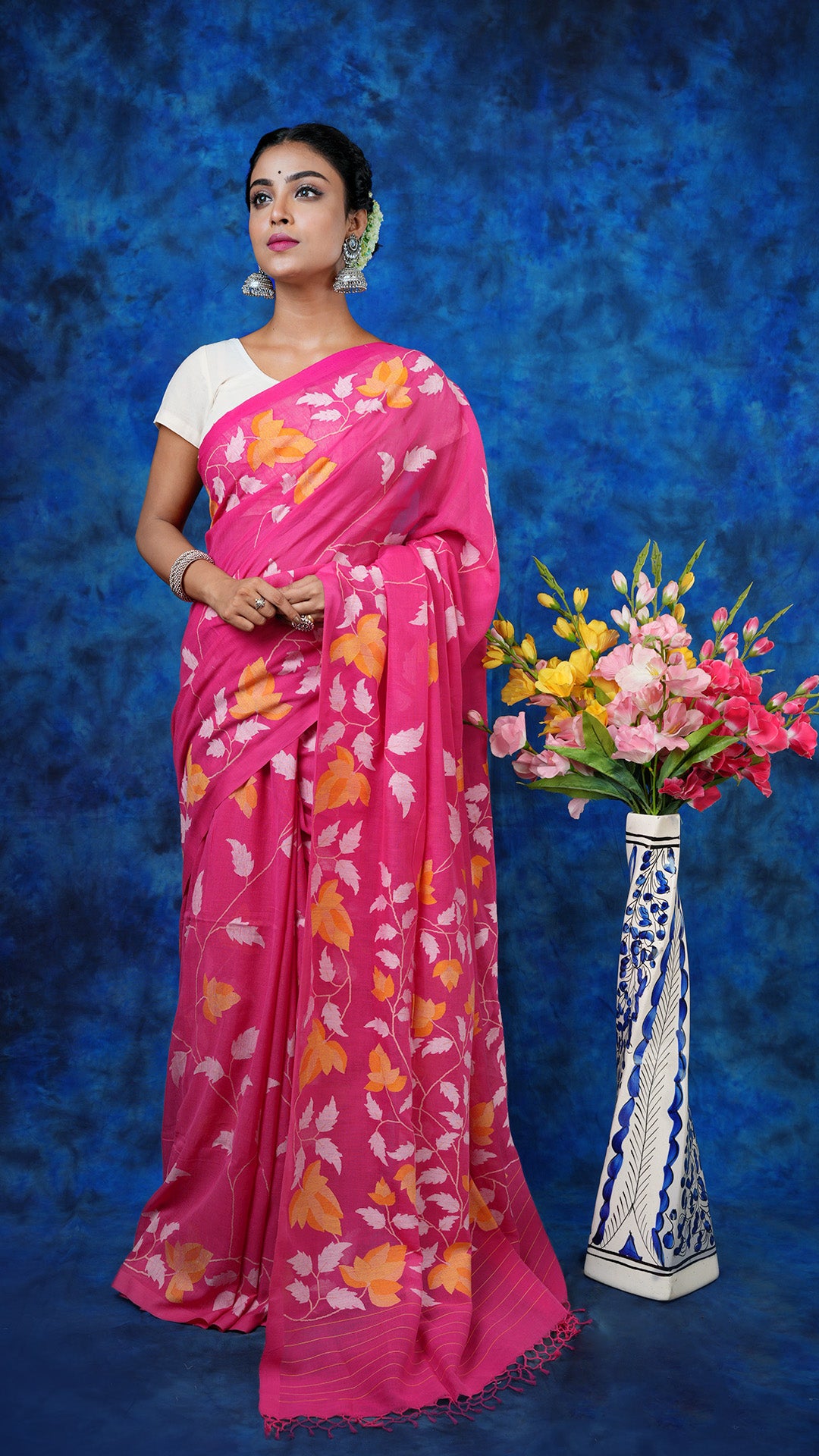A pink floral dhakai saree - A pink soft cotton dhakai saree with floral weaves in white and yellow. This vibrant Dhakai saree is ideal for festive and occasion wear.