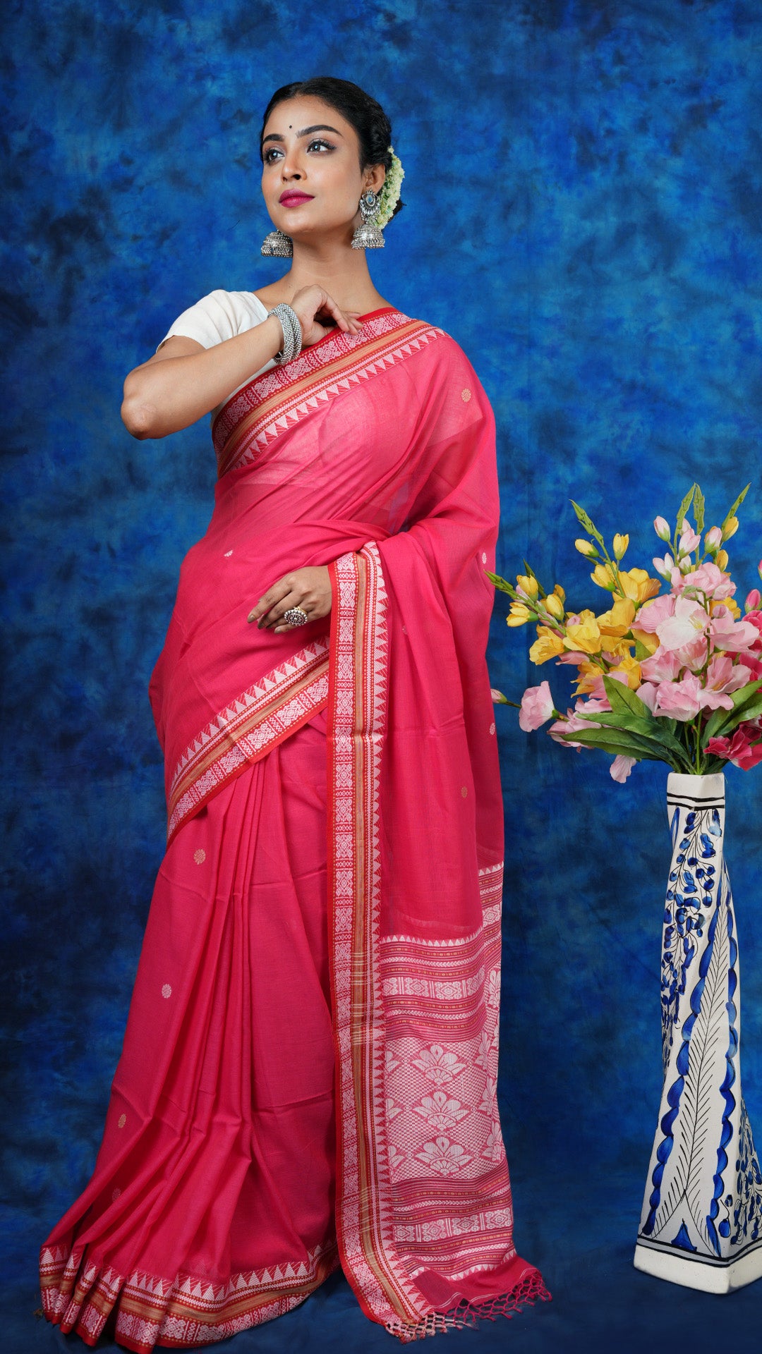 A bright pink tangail saree - A vibrant pink soft cotton tangail saree with white and beige woven motifs. This festive Tangail saree is a bright ethnic wear choice.