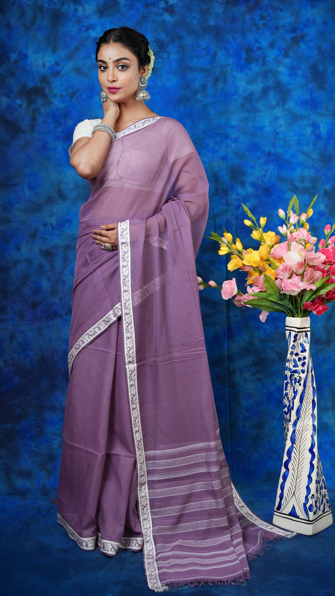  A deep mauve saree with small border - A deep mauve tangail saree with minimal white border and striped pallu. This minimal Tangail saree is perfect for elegant styling.