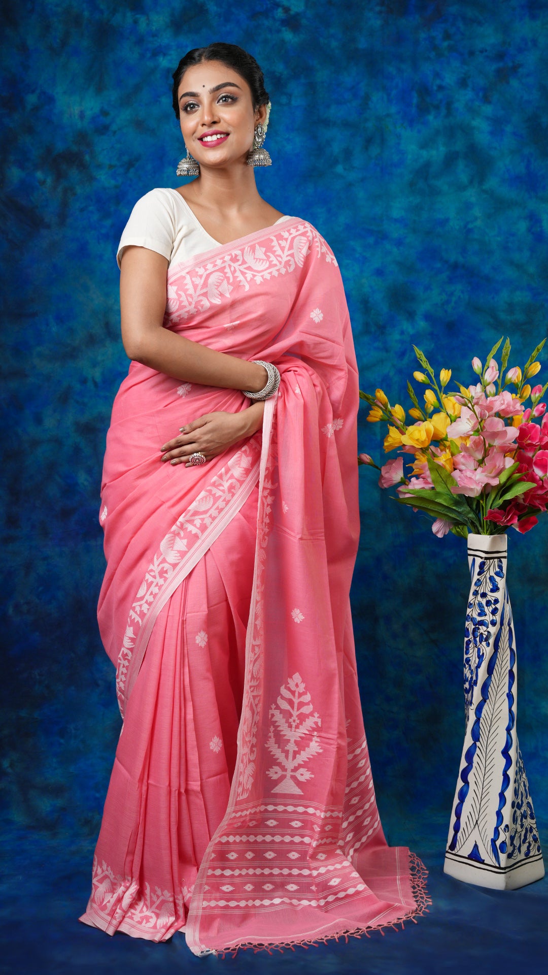 A peach coloured saree - A peach soft cotton saree with white woven motifs and traditional finish. This graceful Dhakai saree, Tant saree is perfect for soft ethnic styling.