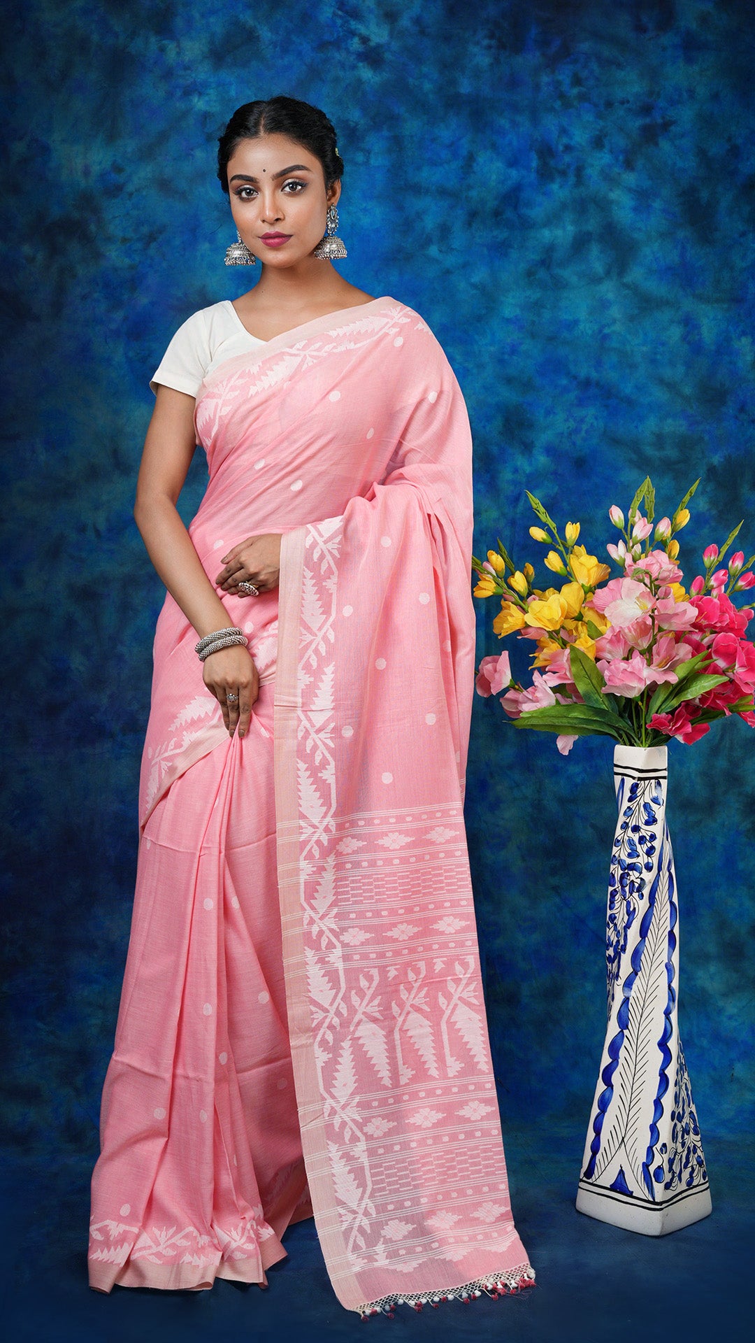 A light peach dhakai saree - A soft cotton dhakai saree in light peach with white traditional motifs. This charming Dhakai saree, Tant saree is ideal for cultural and festive wear.