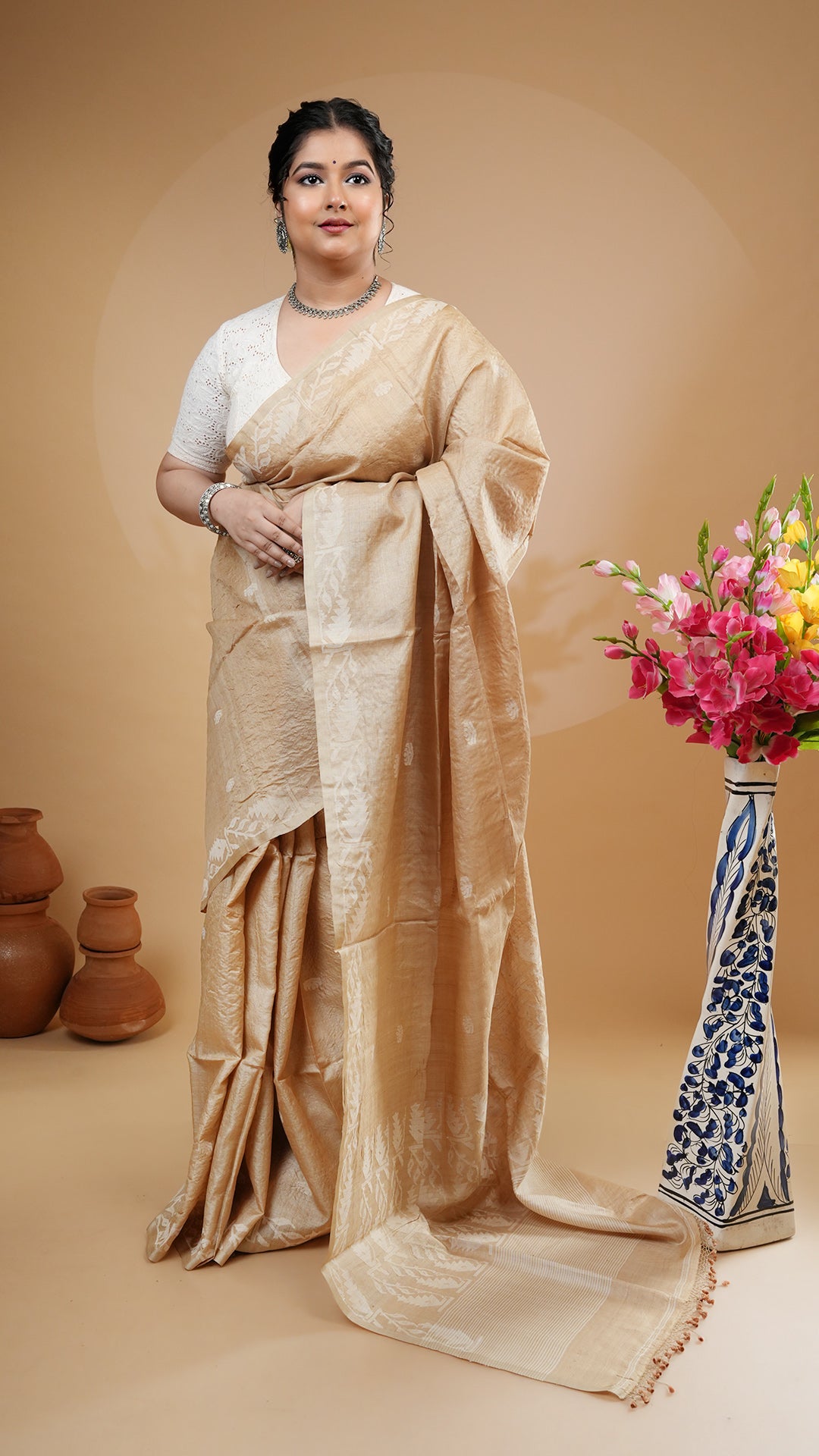 Natural tassar saree with off-white woven motifs on border, butis and pallu. Classic dhakai style tassar saree for weddings and puja.