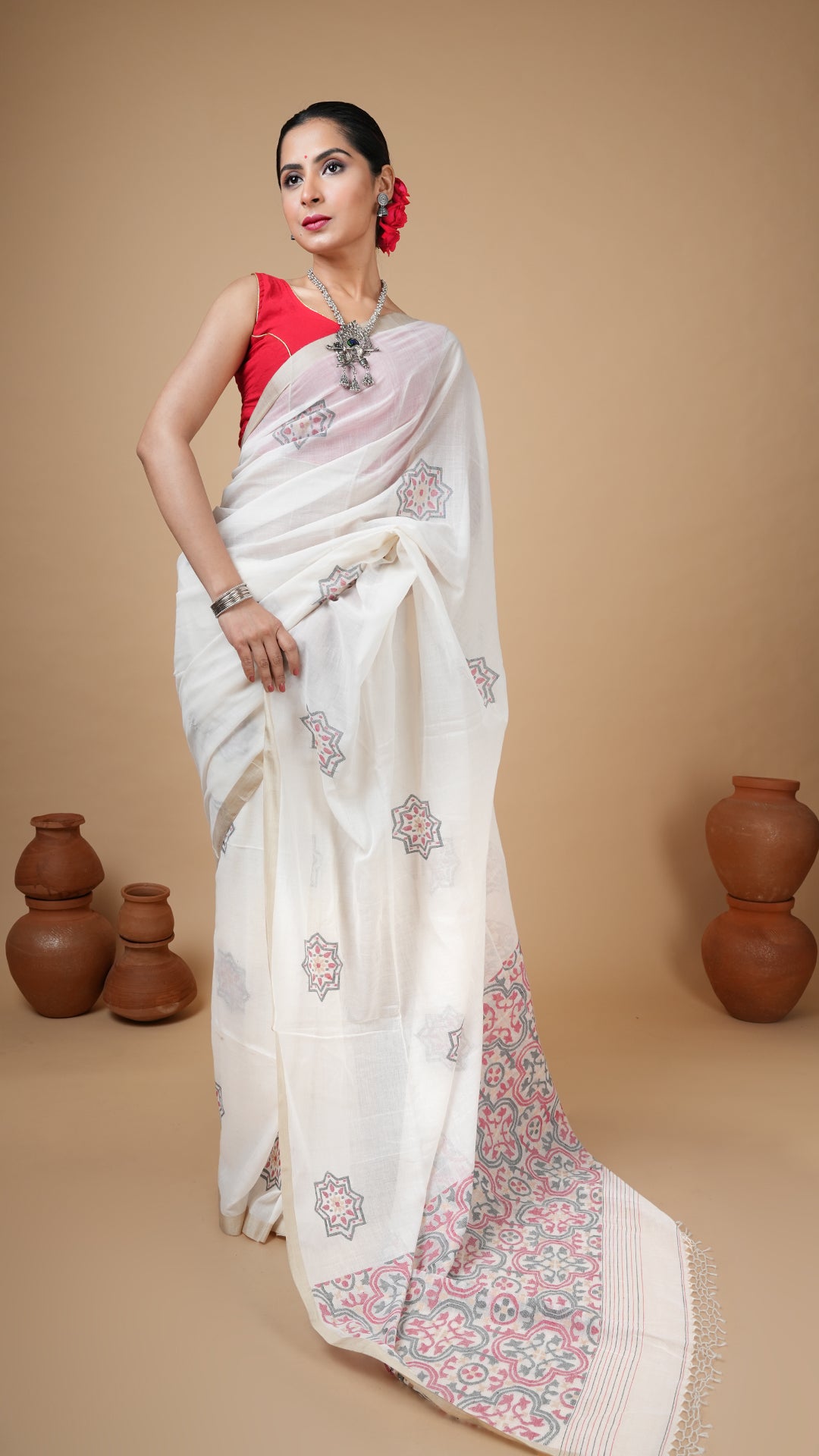 Off-white fine handwoven dhakai saree with black, red and beige motifs. Flat tassar border for a premium festive appeal.
