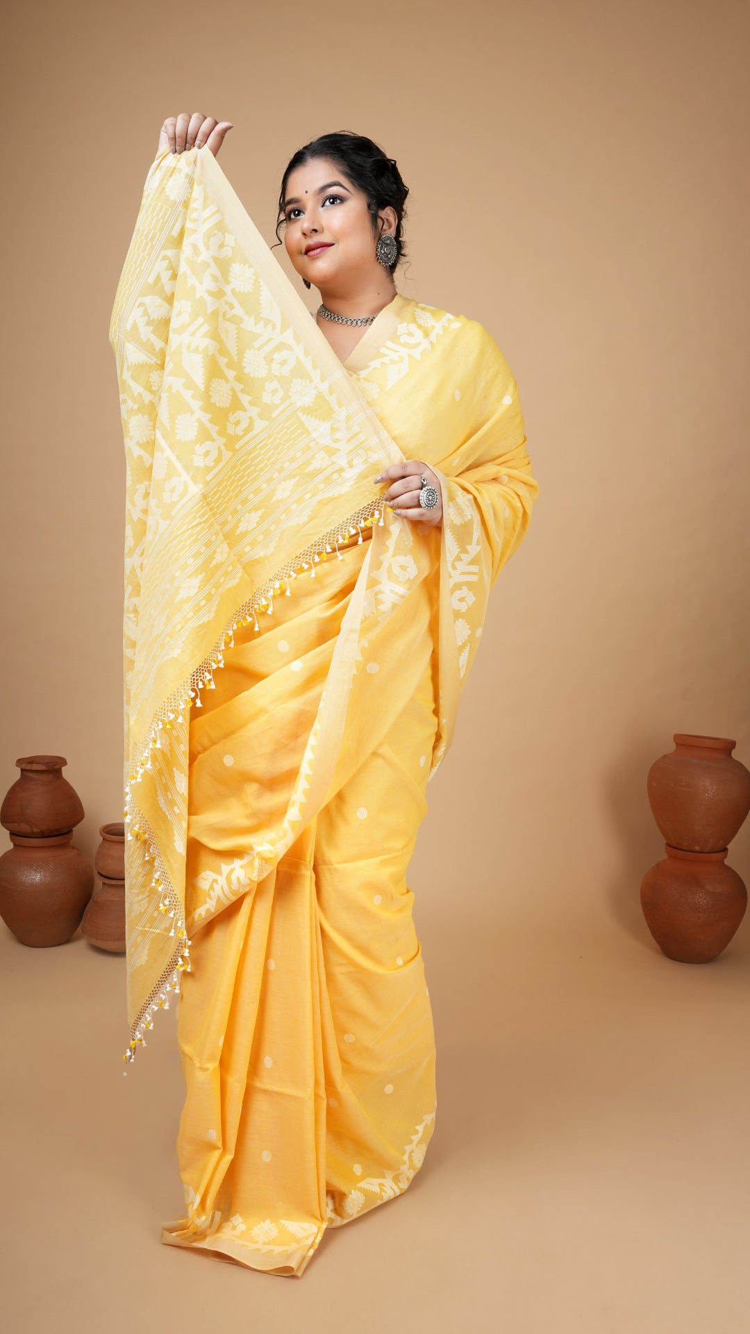 Yellow soft cotton dhakai saree with white woven butis, pallu, and border. Ideal saree for haldi, puja and festive celebrations.