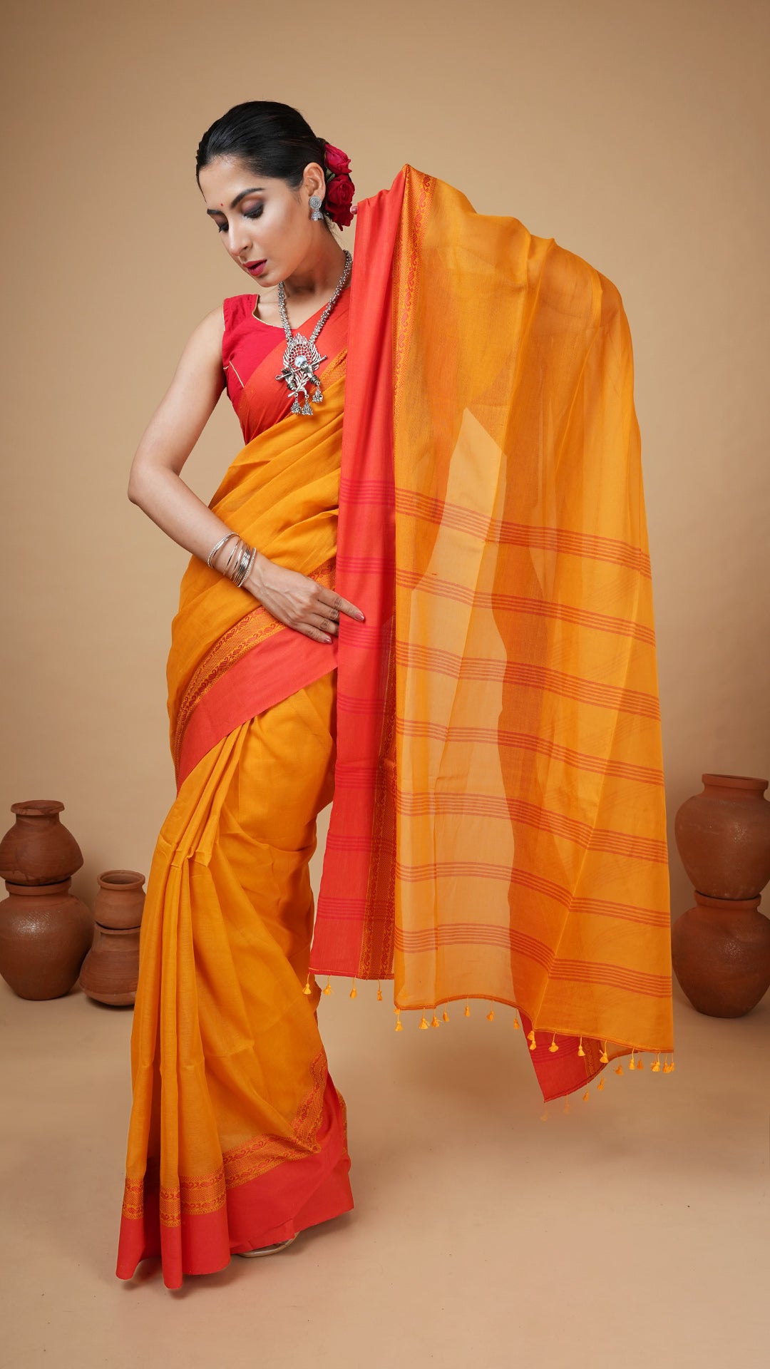 Golden yellow soft cotton tangail saree with red woven border and striped pallu. Simple and vibrant traditional saree for gaye holud.