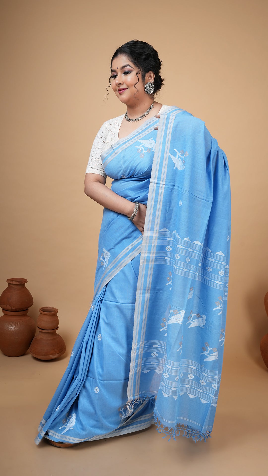 Sky blue soft cotton tangail saree with woven white and beige butis, border and pallu. Elegant festive and gifting saree.