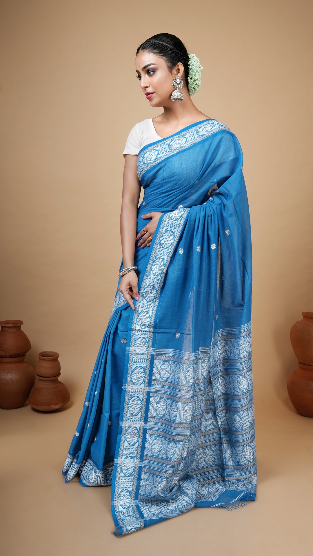 Blue soft cotton tangail saree with white and beige woven border, butis and pallu. Ideal traditional saree for regular or office use.