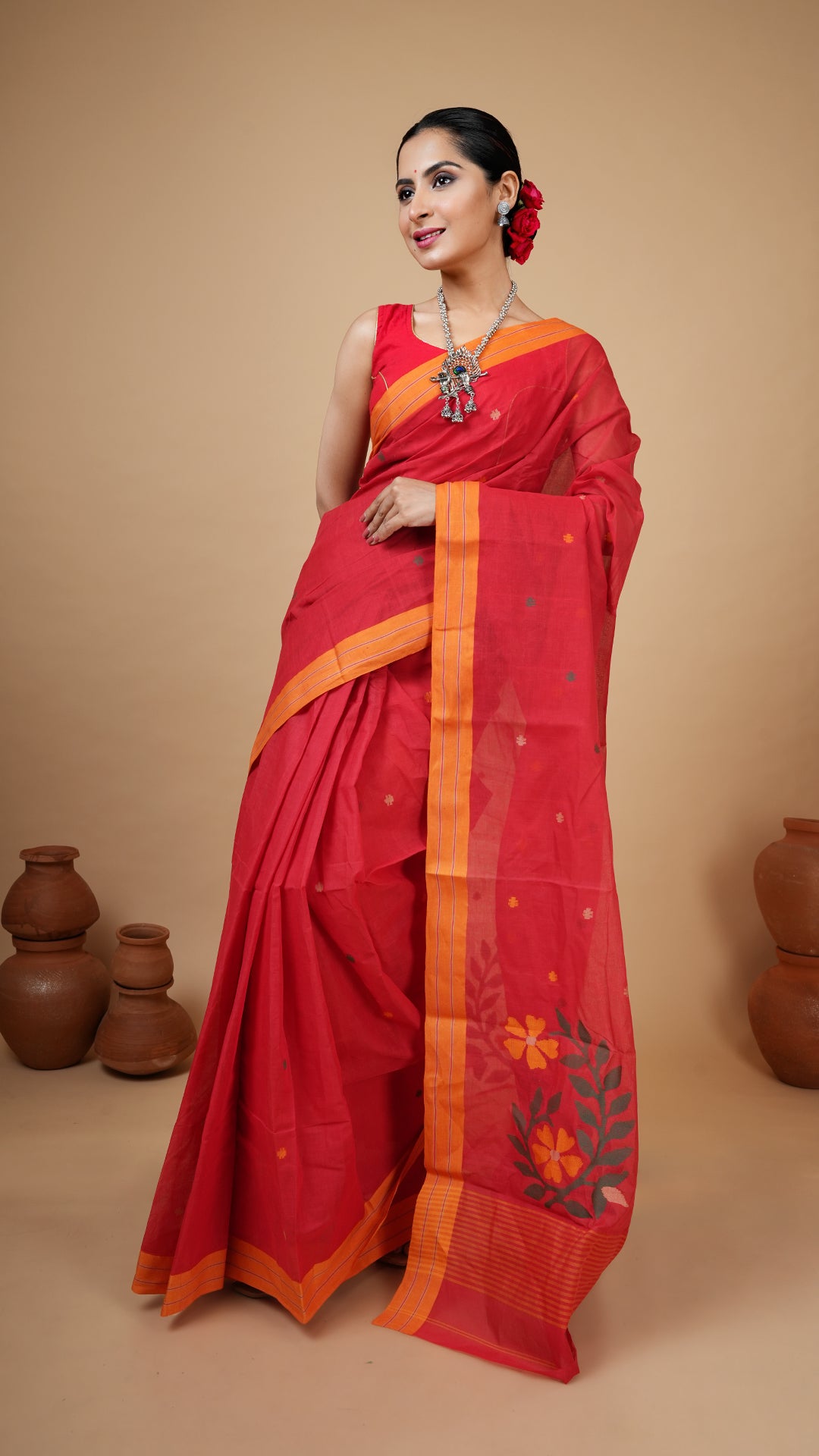 Red cotton dhakai saree with yellow border and green, yellow, beige woven motifs on butis and pallu. Traditional festive look.