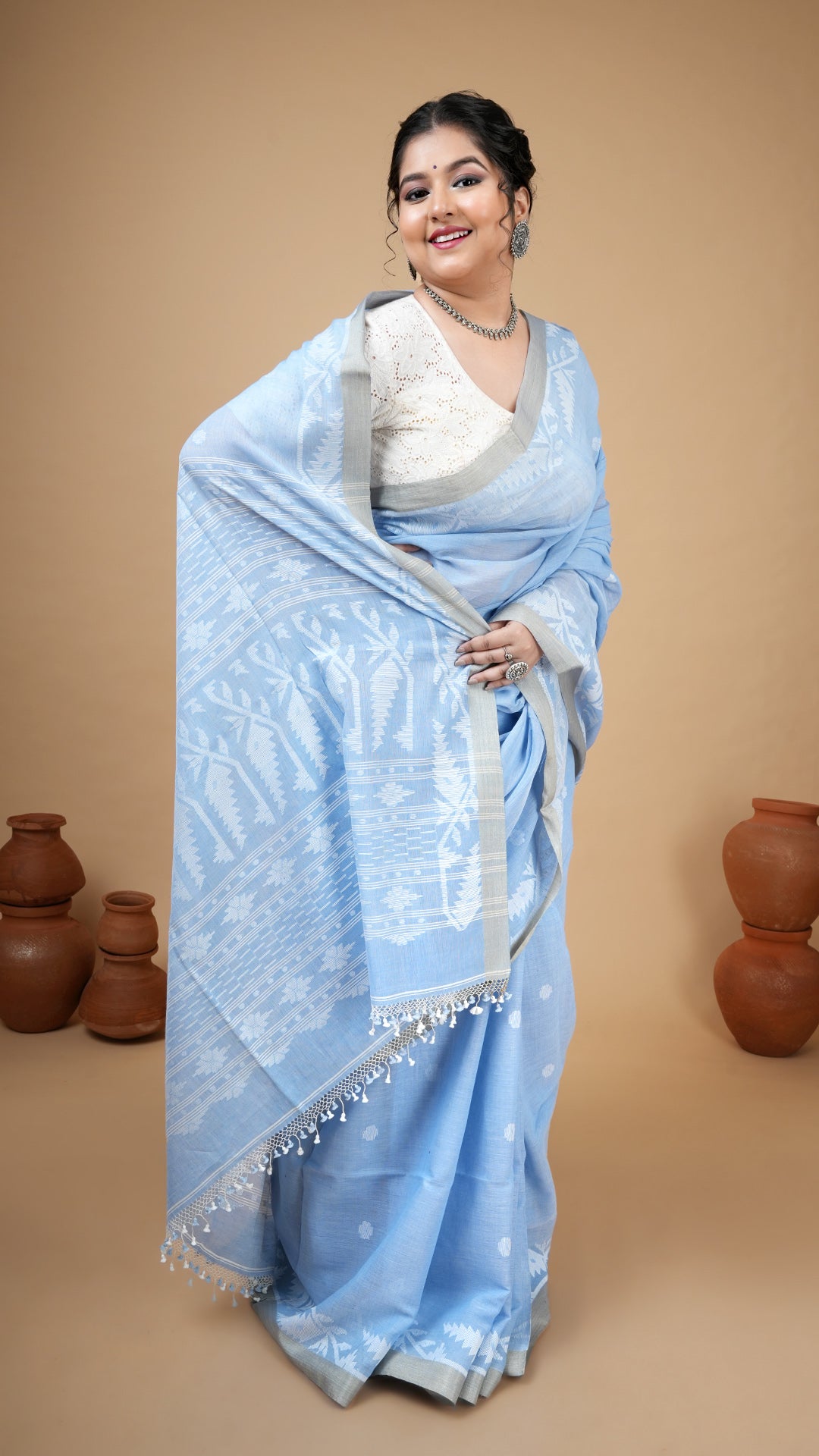 Sky blue dhakai soft cotton saree with white woven butis, pallu, and flat tassar border. Ideal for traditional events and gifts.