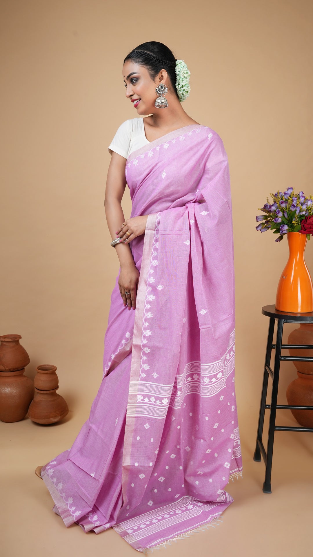 Dual tone mauve tangail saree in soft cotton with white woven butis and pallu. Elegant traditional wear for puja or daily use.