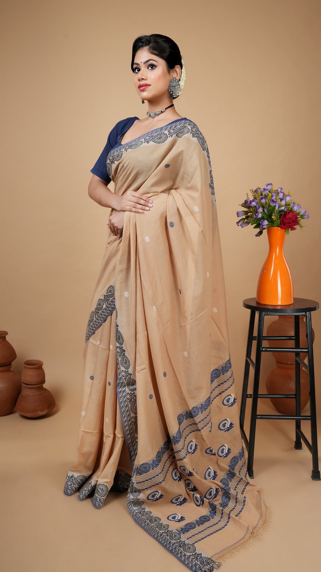 Beige tangail saree with blue border, white and blue woven butis and pallu. Office-appropriate traditional soft cotton saree.