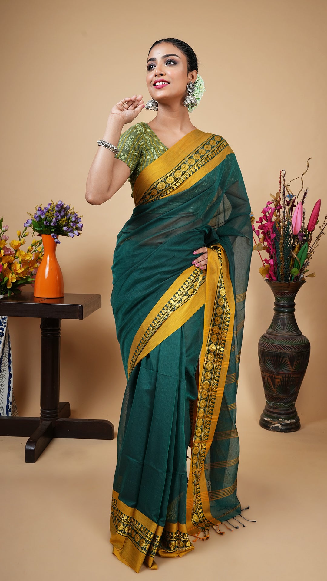 Deep green soft cotton tangail saree with yellow woven border and striped pallu. No butis. Subtle office or daily wear.