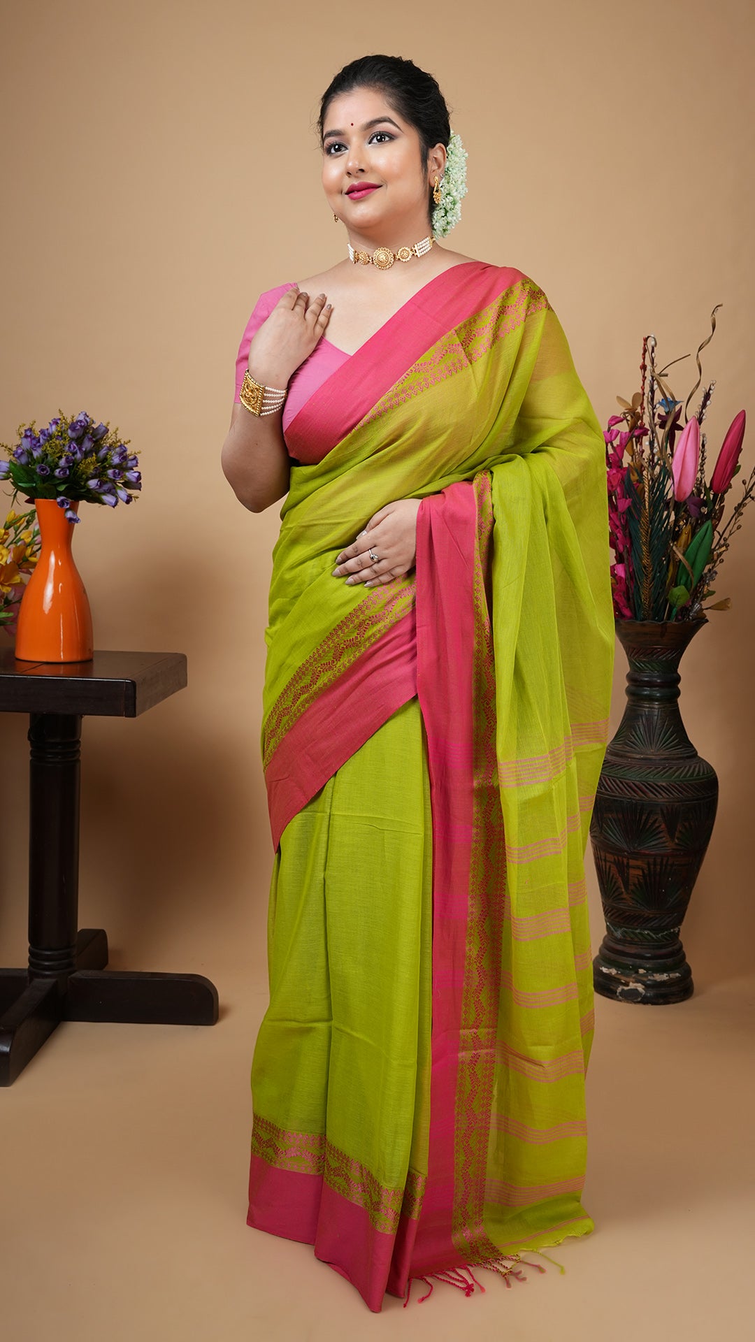 Green soft cotton tangail saree with pink woven border and striped pallu. No butis. Traditional lightweight office saree.