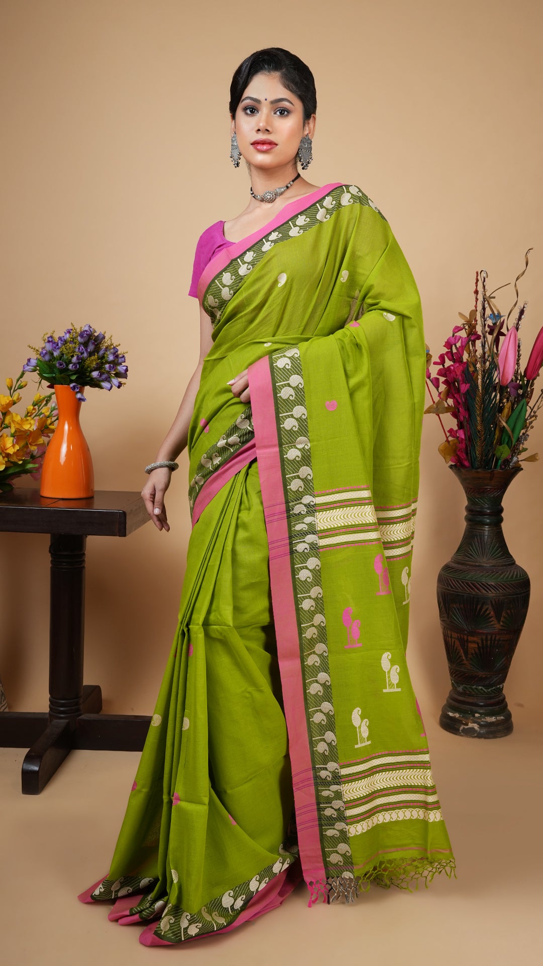 Green tangail soft cotton saree with off-white and pink woven butis, border and pallu. Perfect for office or regular wear.