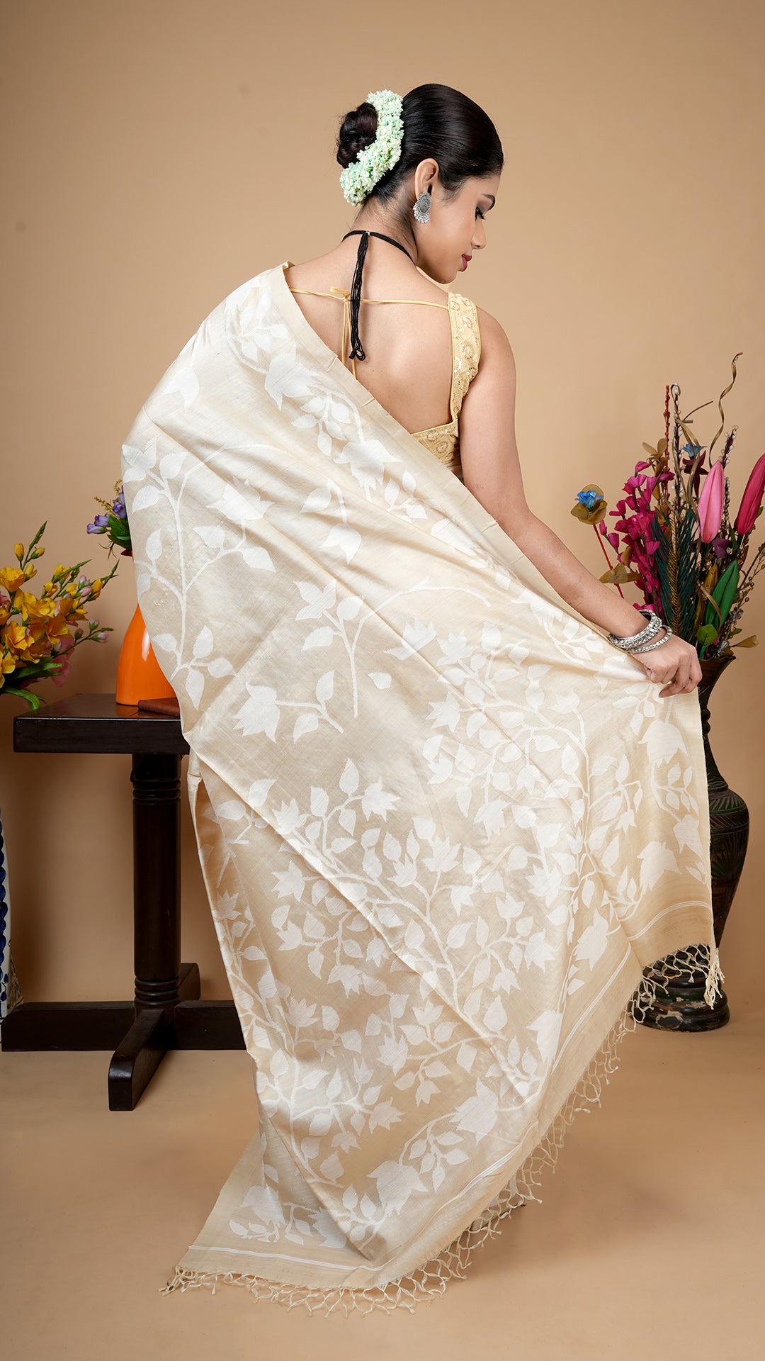 A tassar all over saree back view in off white dhakai weave, intricate all-over floral pattern with soft tassel pallu detailing